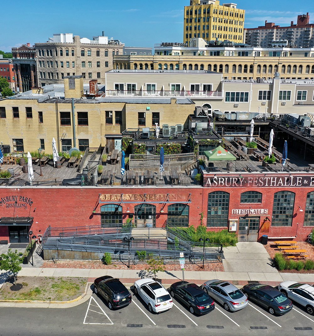 Brick commercial building with rooftop dining patios and Asbury Park Distilling and Bierhalle signs.