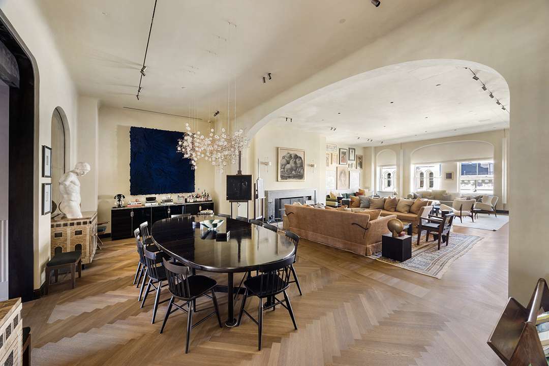 Gallery-style dining area in the four-story SoHo penthouse featuring atmospheric lighting, sculptural furniture, and views over downtown Manhattan, curated by Axel Vervoordt.