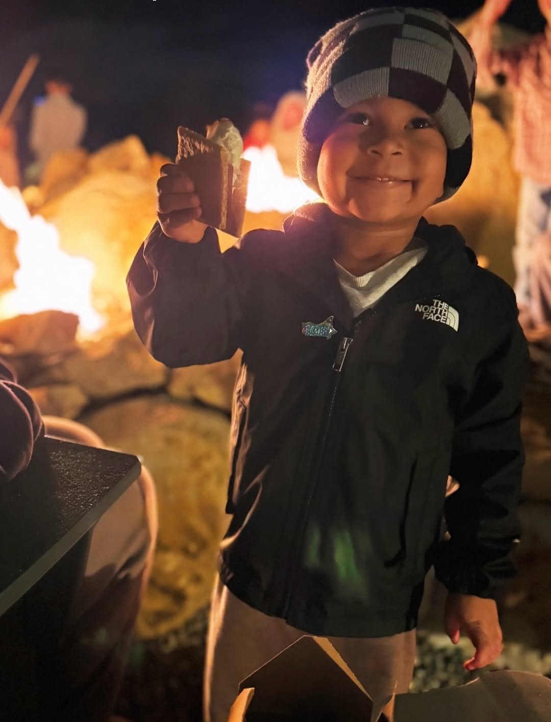 Cozy outdoor fire pit scene with marshmallows roasting on sticks, chocolate, and graham crackers ready for s'mores, evoking sweet moments, new beginnings, and 2026 real estate dreams under twinkling night sky