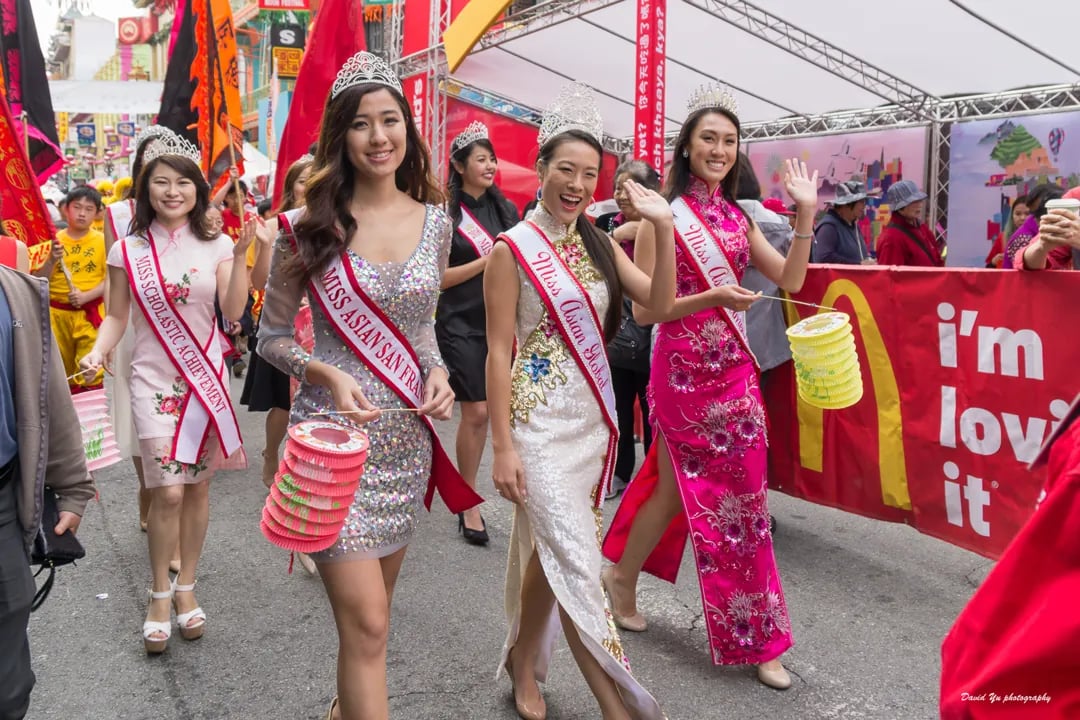 Winners of the Miss Asian San Francisco pageant in dresses and sashes, holding lanterns during a festival parade.