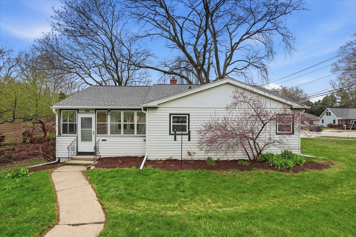 Front exterior view of the mid-century home at 102 W Lakeview Avenue in Madison, Wisconsin, showing the paved walkway, mature trees, and classic ranch architecture.
