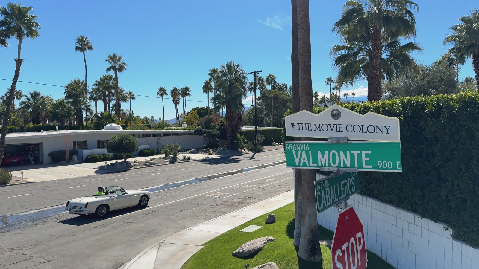 The Movie Colony and Valmonte street signs beside a palm-lined road in Palm Springs