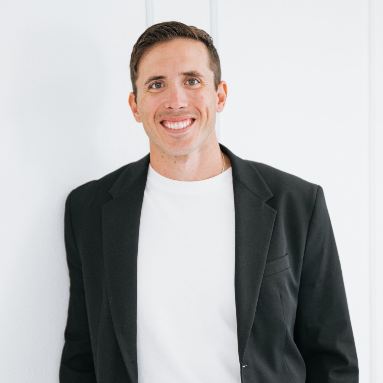 Zach Schottenstein smiling in a black blazer and white shirt.