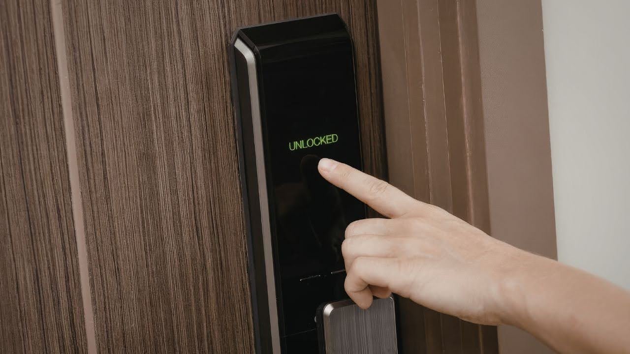 a-hand-touches-a-digital-door-lock-with-a-bright-display-reading-unlocked-in-green