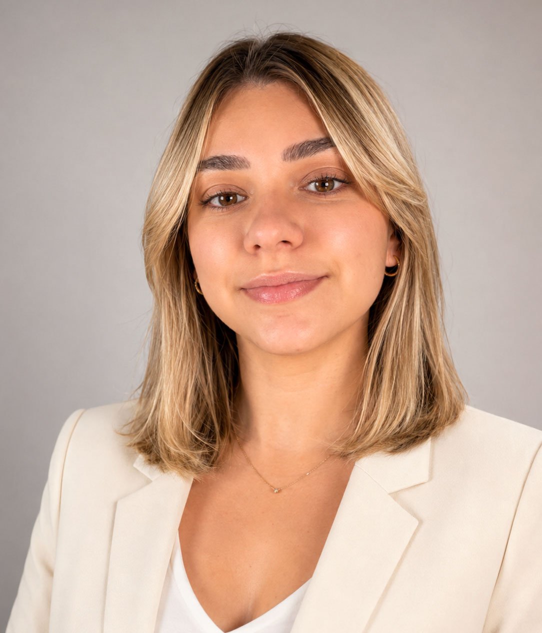 Lais Murphy, real estate agent, wearing a white blazer against a plain gray background.