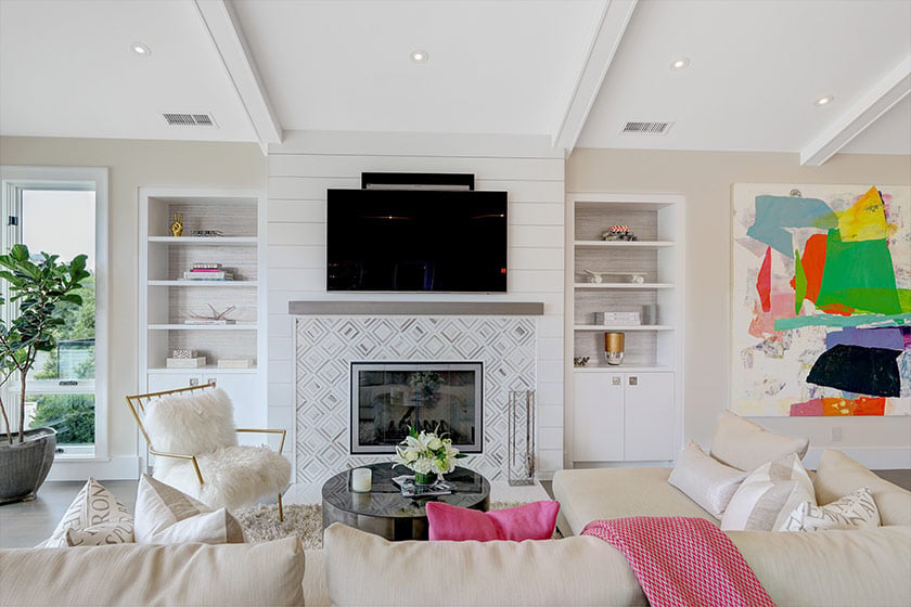 Staged living room with a patterned fireplace, built-in shelves, and colorful abstract artwork.