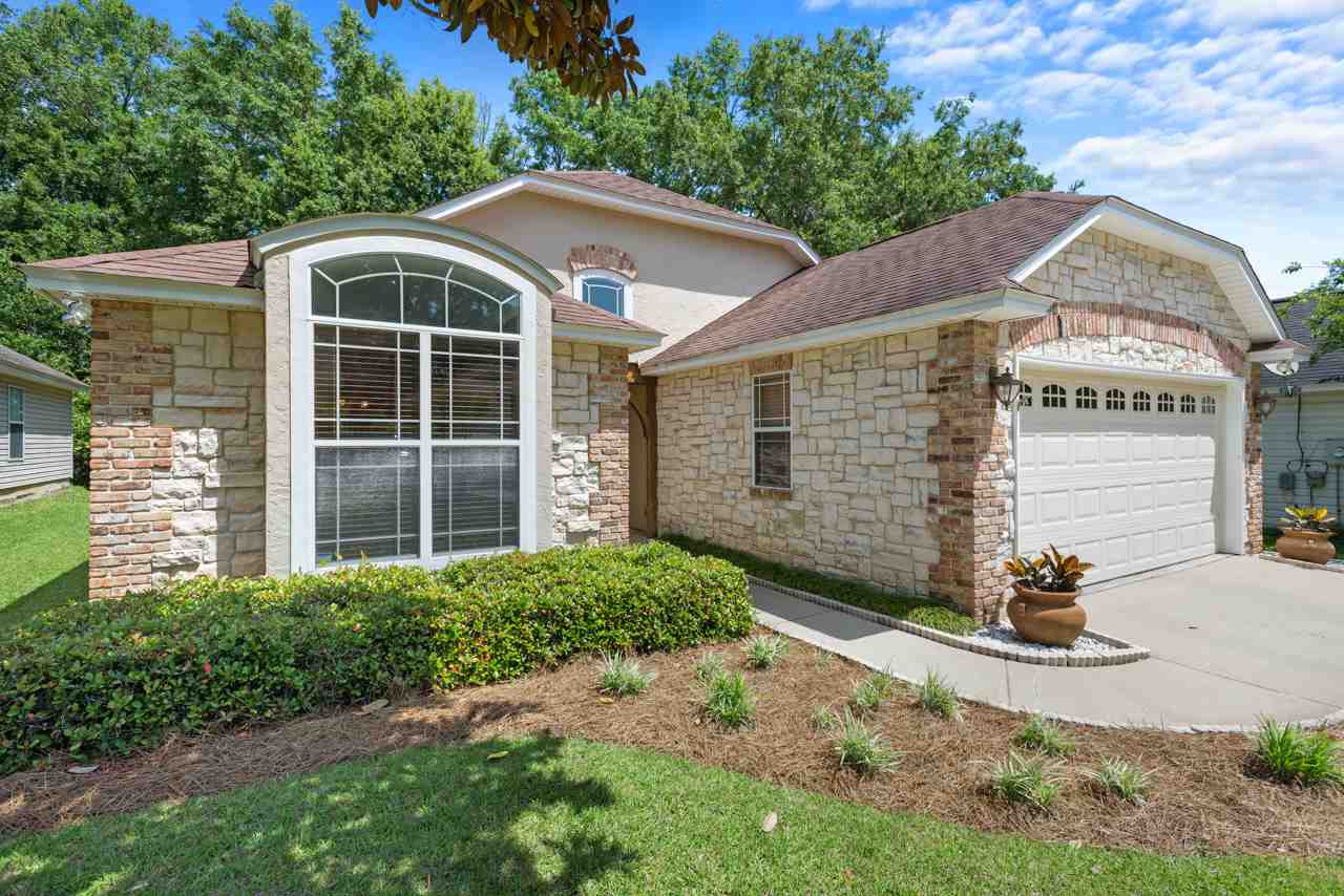 A residential home featuring a garage and a paved driveway, showcasing a welcoming exterior.