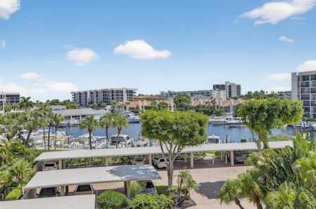 Waterfront residential complex with a marina, mid-rise buildings, and tropical landscaping.