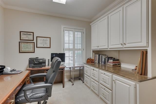 Home office with white built-in cabinetry, a long counter, and a desk beside a shuttered window.