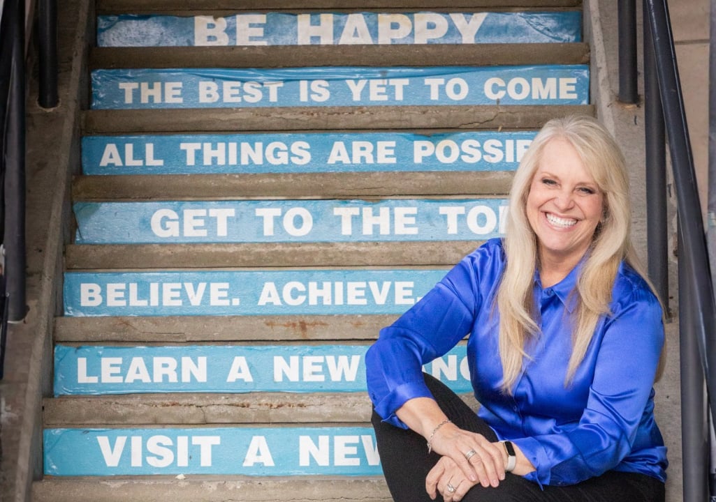 Sharla Ellis sitting on steps labeled with positive phrases, representing multiple home buying options