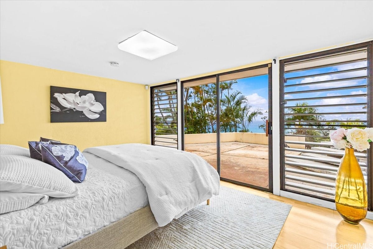 Bedroom with sliding glass doors opening to a terrace and ocean view.