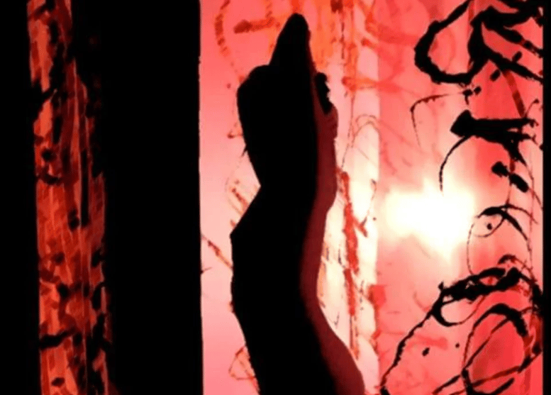 Abstract red-and-pink artwork with a dark silhouette-like form and expressive black marks.