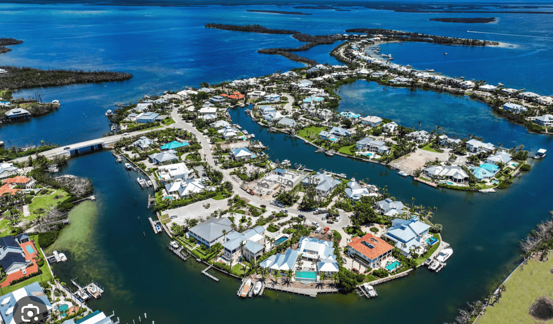 Aerial view of Boca Grande Isles homes lining canals, with docks, boats, and a bridge.