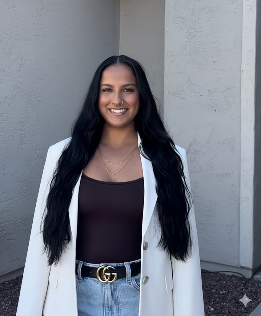 Serenity Swamy smiling in a white blazer and dark top.