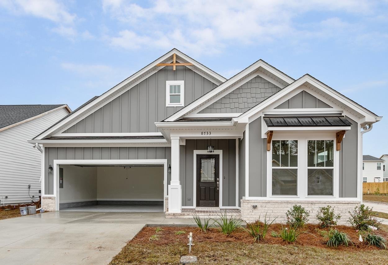 A gray house featuring a garage and white trim, showcasing a classic and inviting architectural style.