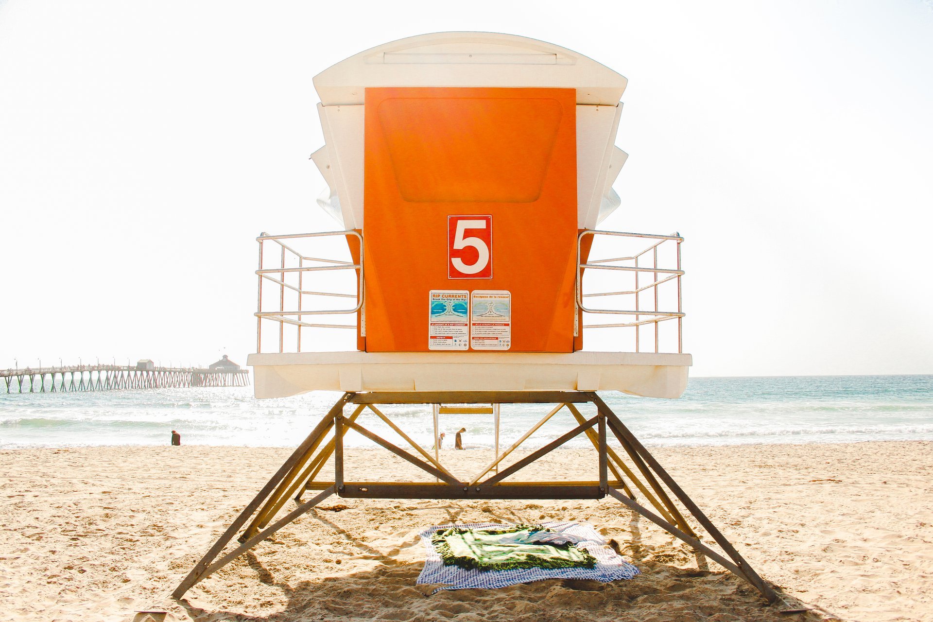 Orange City of Imperial Beach lifeguard tower number 5 on the sand with the Imperial Beach Pier in the background, August 2016