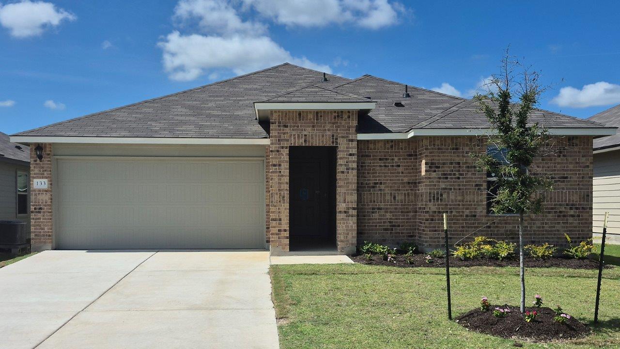 Single-story brick home with an attached two-car garage and landscaped front yard.