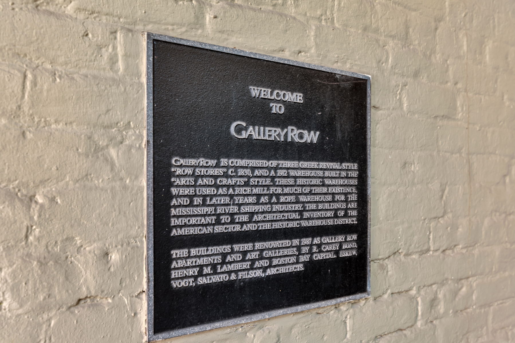 Gallery Row historical plaque mounted on a pale brick wall.