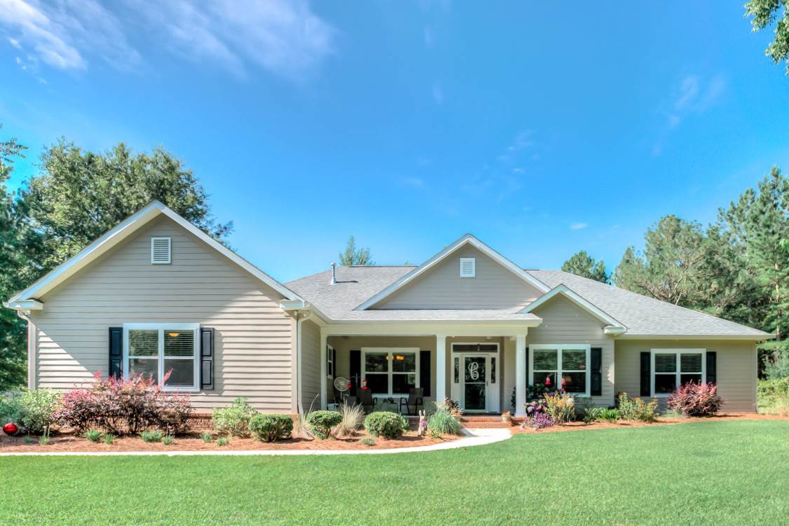 A spacious home surrounded by a large, lush green yard, showcasing a vibrant grass landscape.