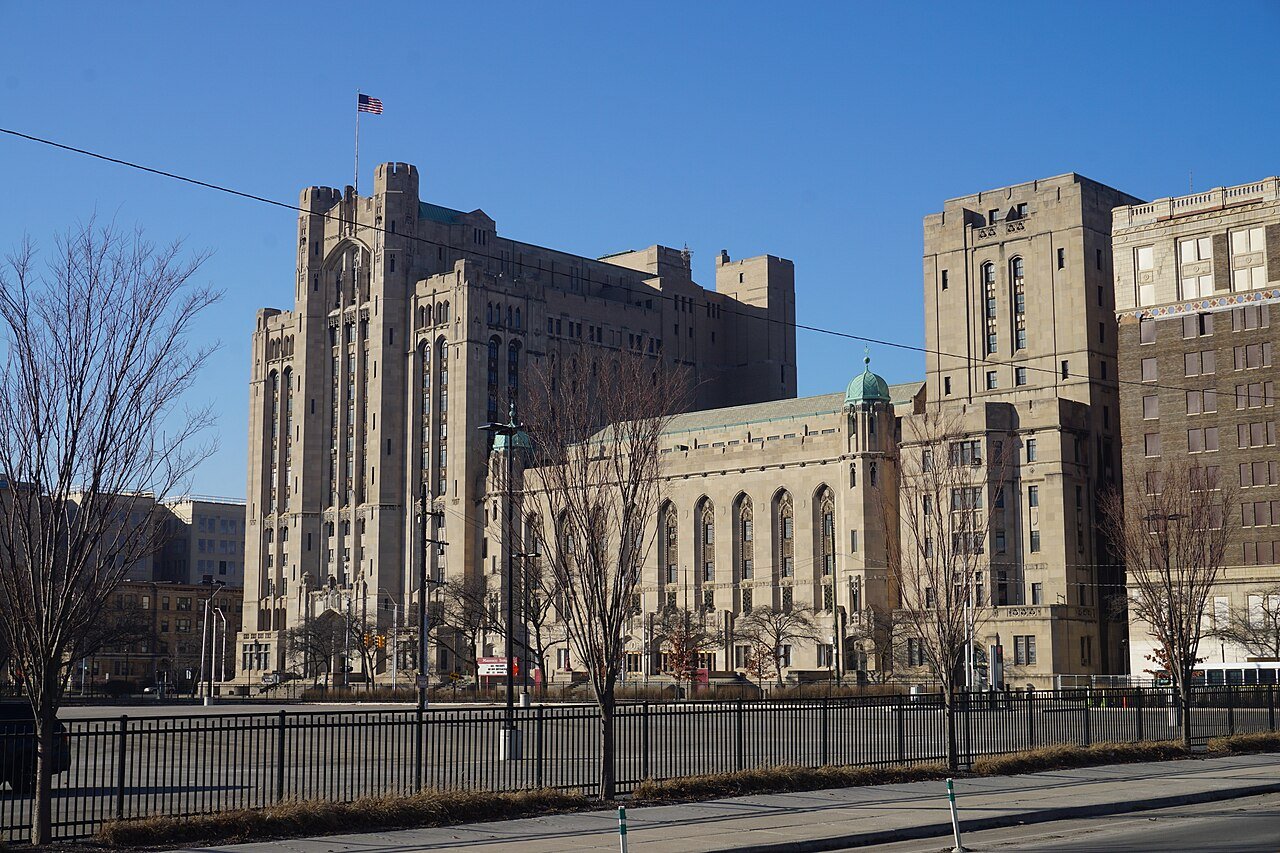 Detroit Masonic Temple with tall stone towers, a green dome, and an American flag.