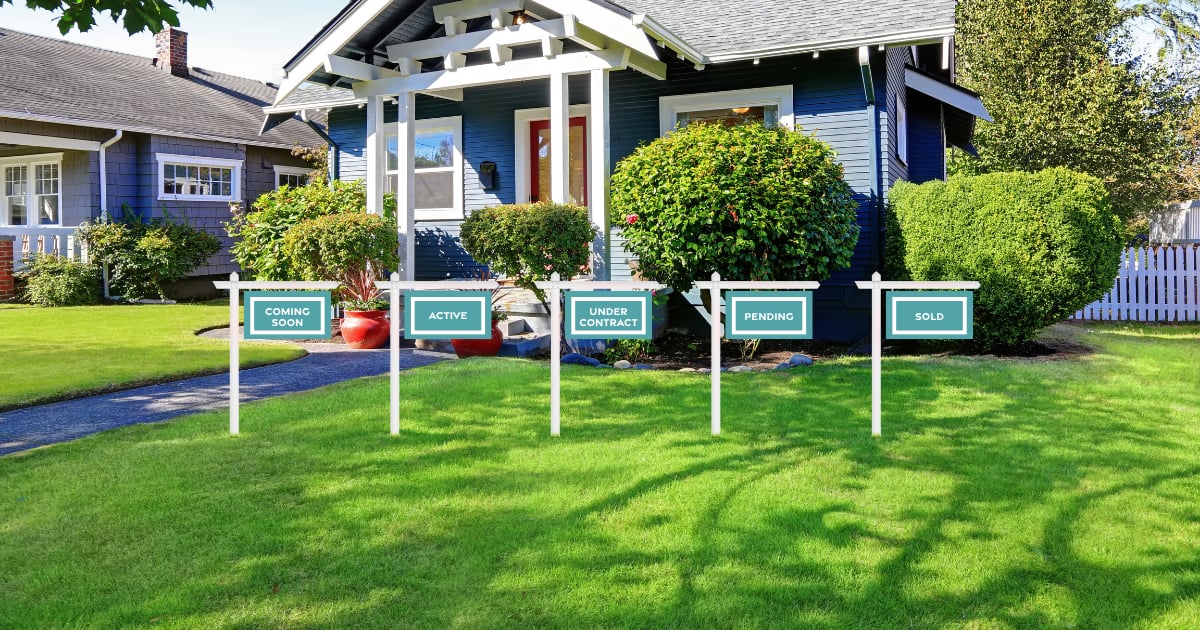 Blue-sided house with a green lawn and five real estate status signs.