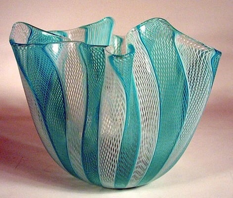 Turquoise and white glass vessel with an undulating rim and intricate crisscross patterns.