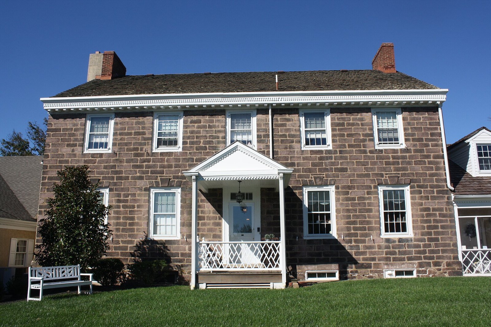 Historic fieldstone Twin Trees Farm house under a clear blue sky in Richboro, PA