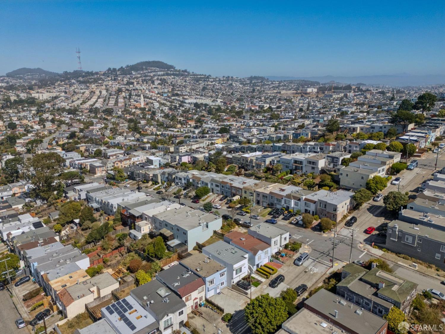 Aerial view of San Francisco homes, with dense streets in the foreground and houses covering distant hills.