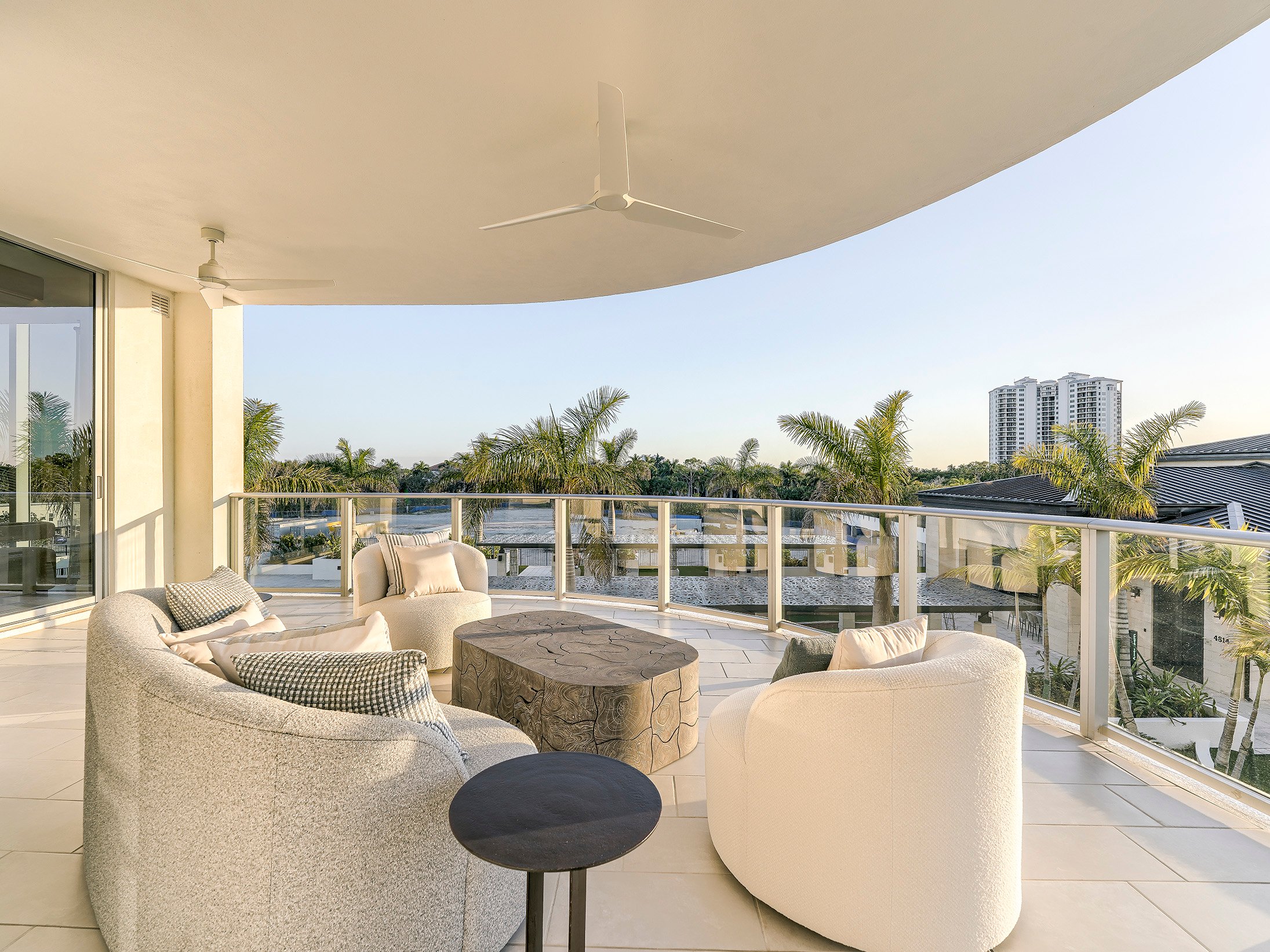 Living room opening to a wide terrace with treetop views at Infinity at The Colony
