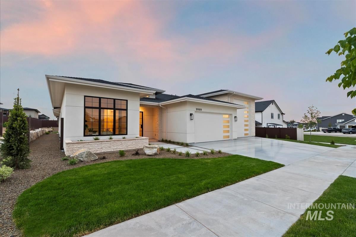 Single-level new home with white exterior, black steel windows and grassy front yard