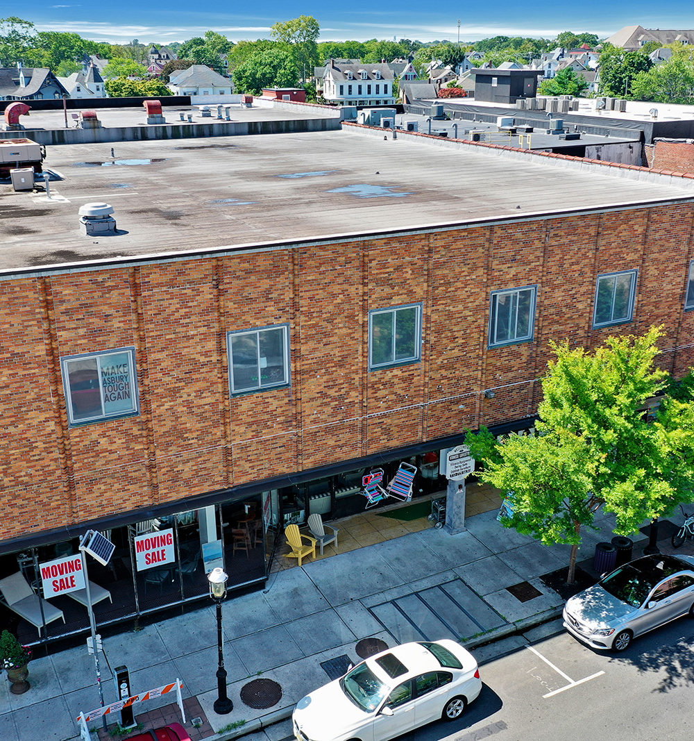 614 Cookman Avenue, a brick commercial building with a flat roof and storefront windows, viewed from above.