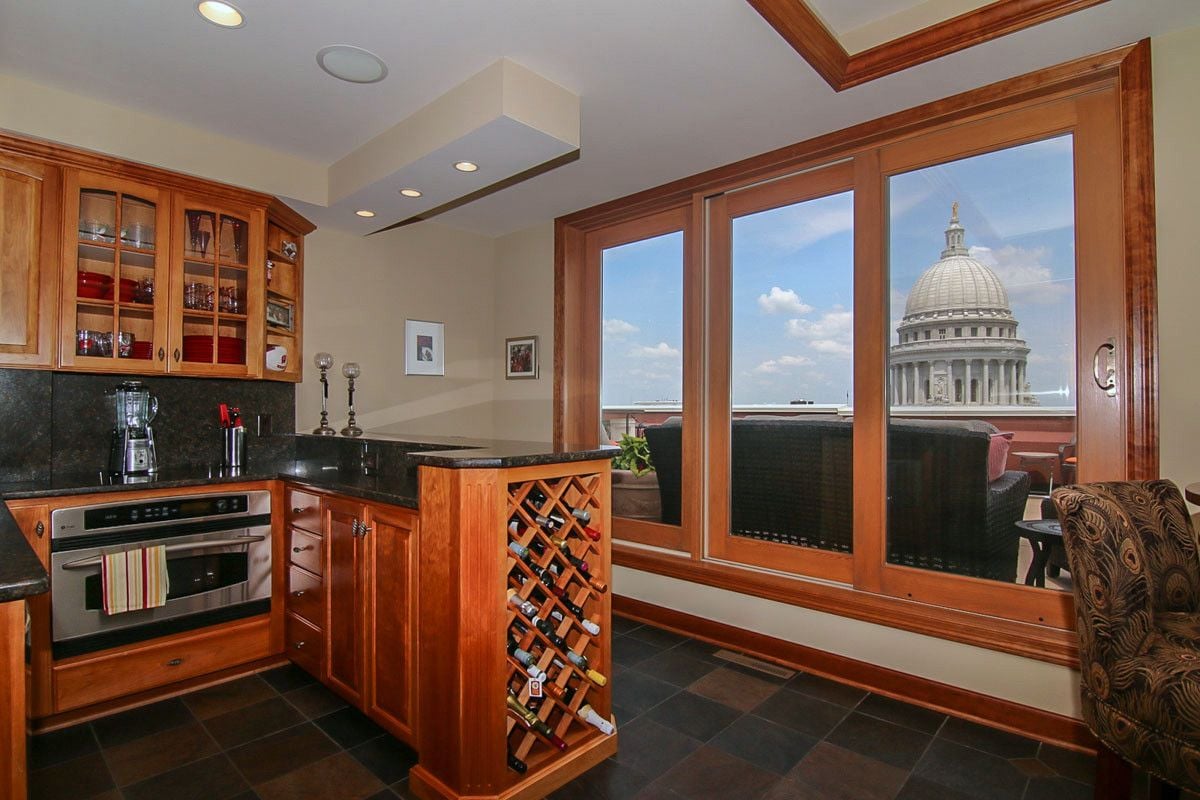 Penthouse kitchen with a built-in wine rack and glass doors framing the Wisconsin State Capitol dome.