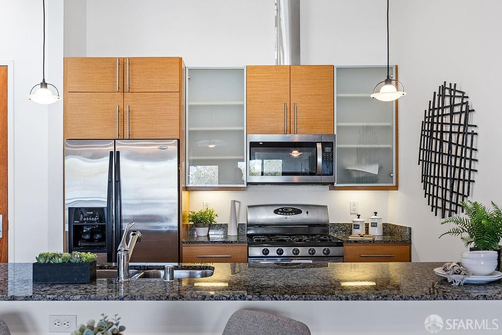 Modern kitchen with wood cabinets, stainless steel appliances, and a granite island.