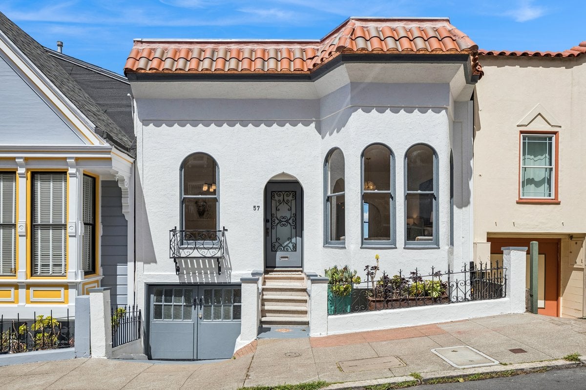 Front exterior of 57 Montezuma Street, a white stucco Bernal Heights home with arched windows, tile roof and garage. Listed & sold by Jessica Rucker, realtor