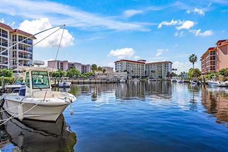 Canal in East Boca Raton lined with condominium buildings, with a white boat moored in the foreground.
