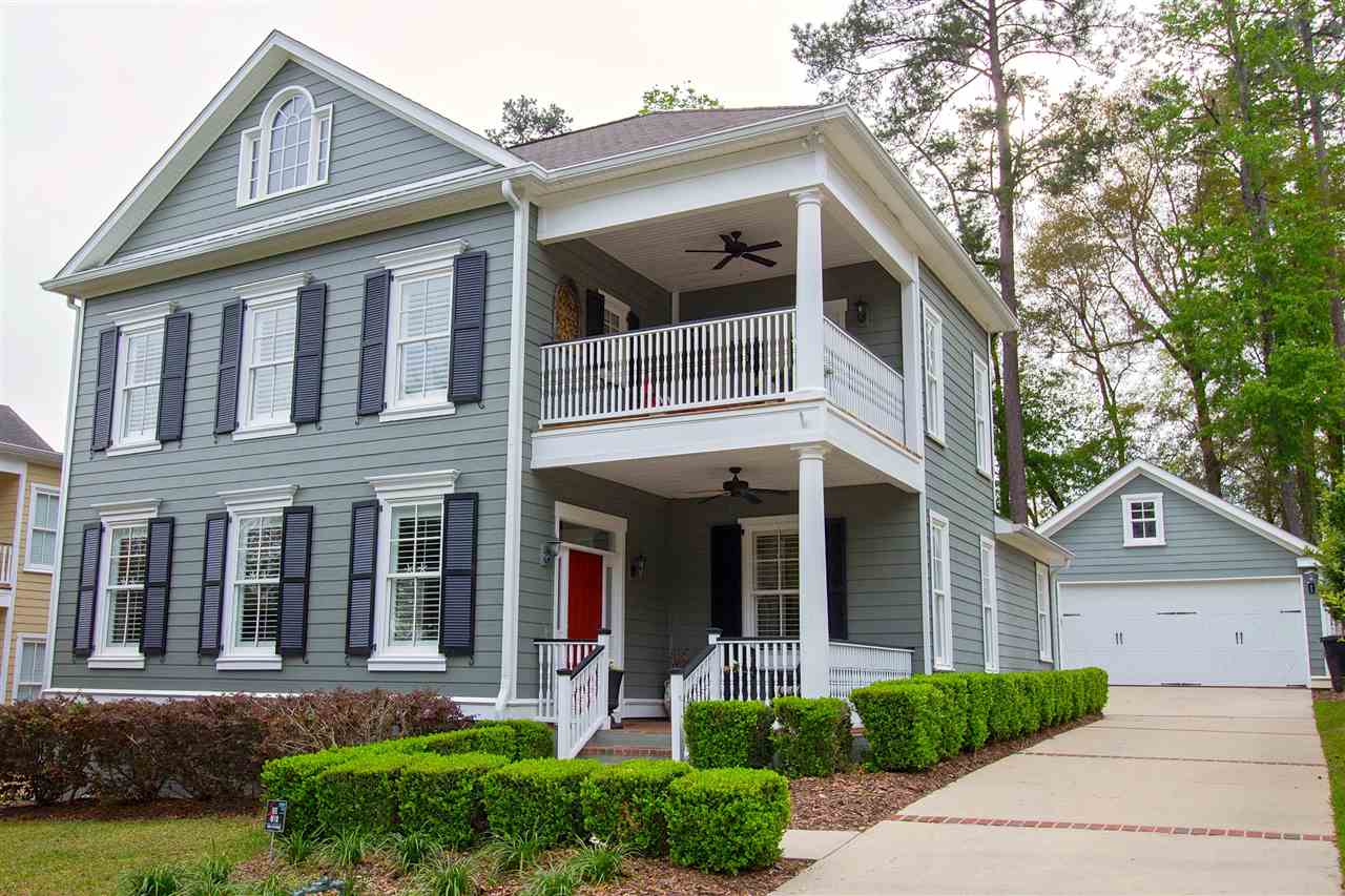 A two-story home featuring a welcoming front porch and a well-maintained front yard.