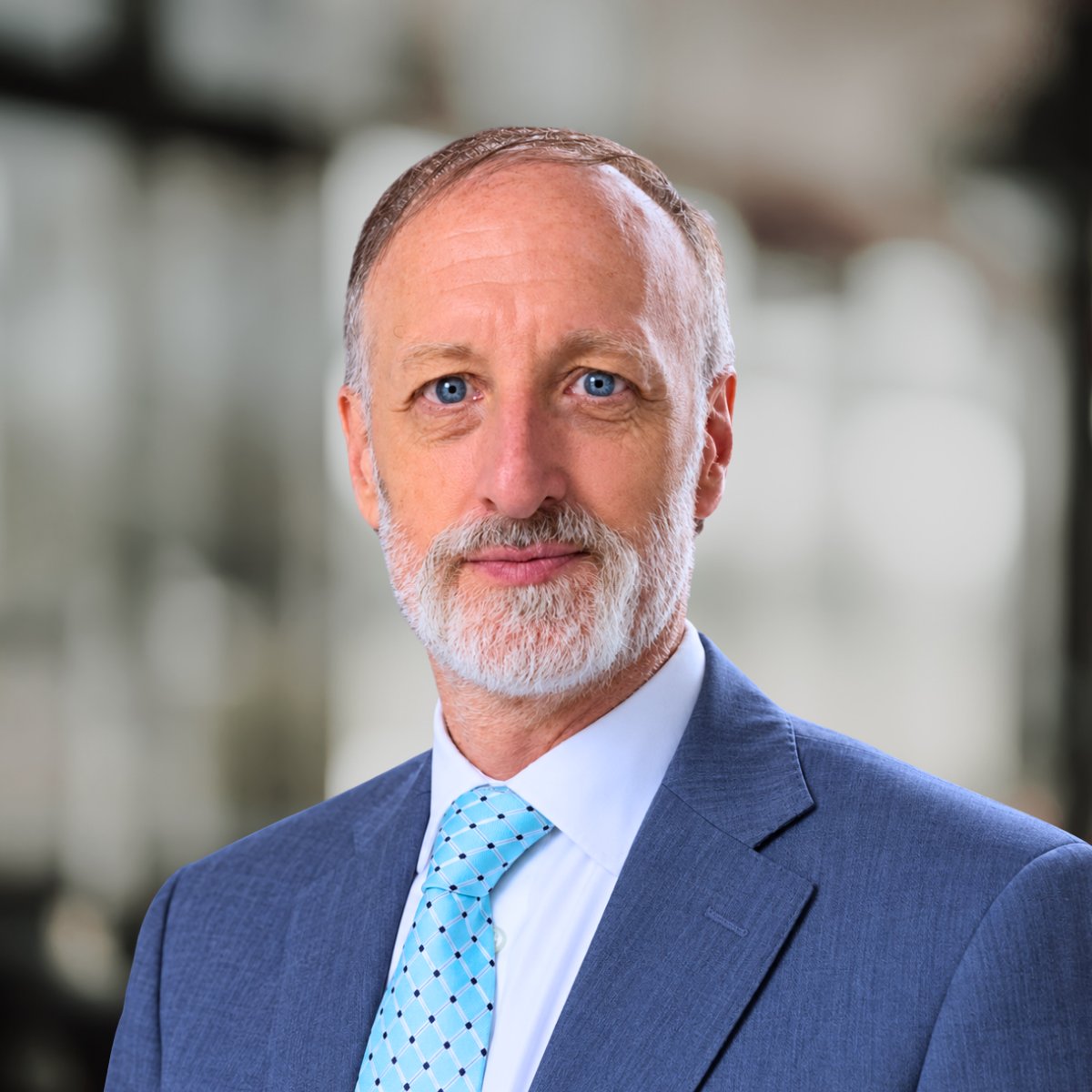 Sean Sutherland in a blue suit and light blue patterned tie.