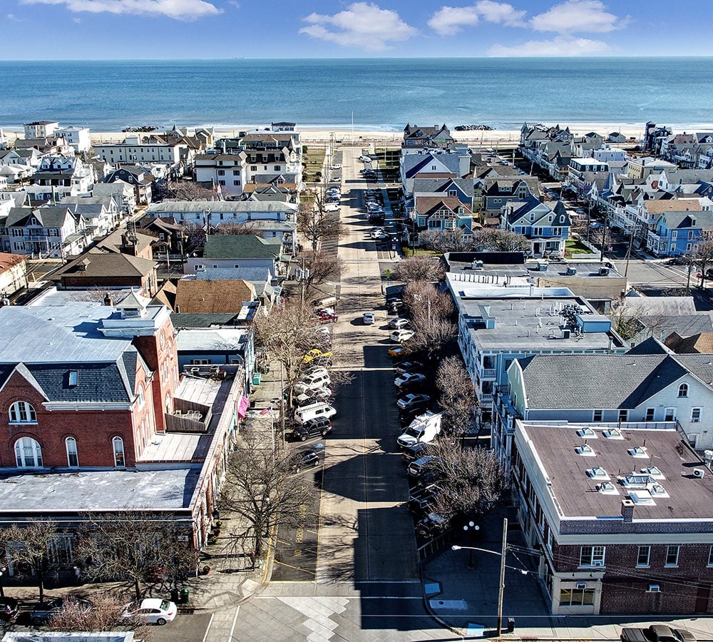 Aerial view of an Ocean Grove street leading to the beach, with the ocean beyond.