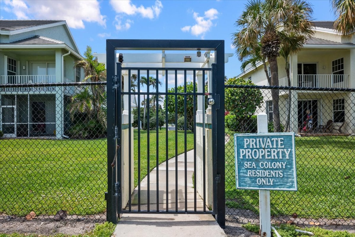 Sea Colony condominium entrance with a gated walkway and residents-only sign.