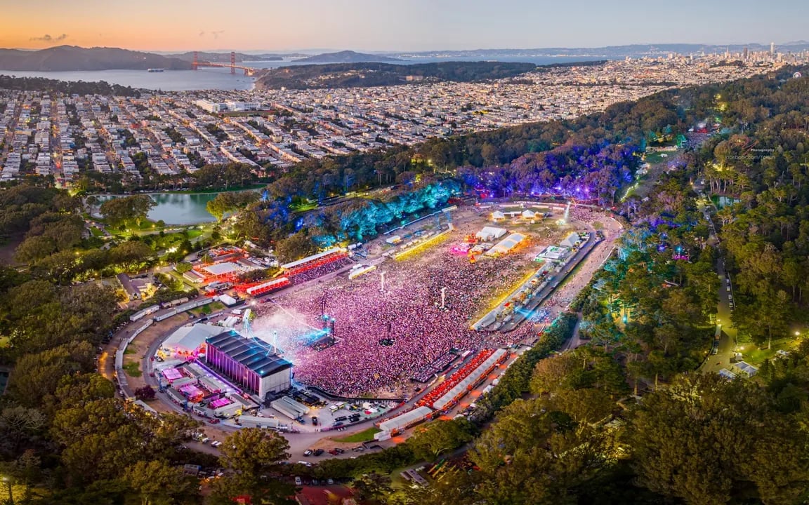 Aerial view of Golden Gate Park during Outside Lands showing the main stages and crowds spread across the lush green landscape