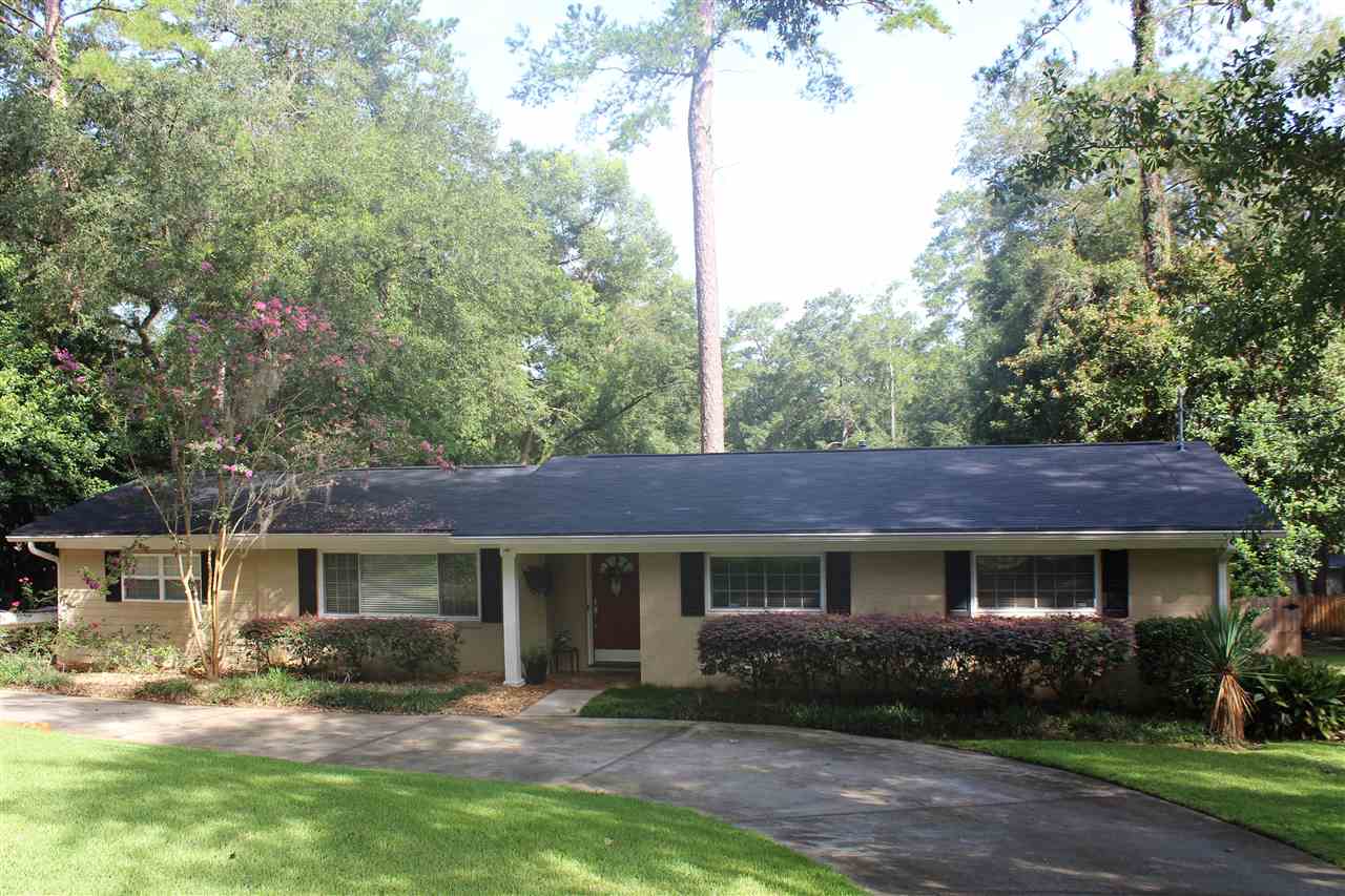 long spacious home surrounded by trees