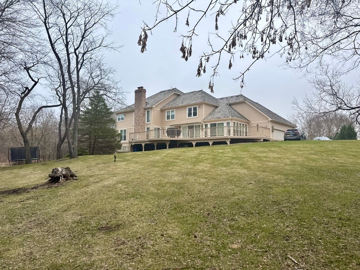 Back of home with large tiered wrap around deck leading to walkout lower level