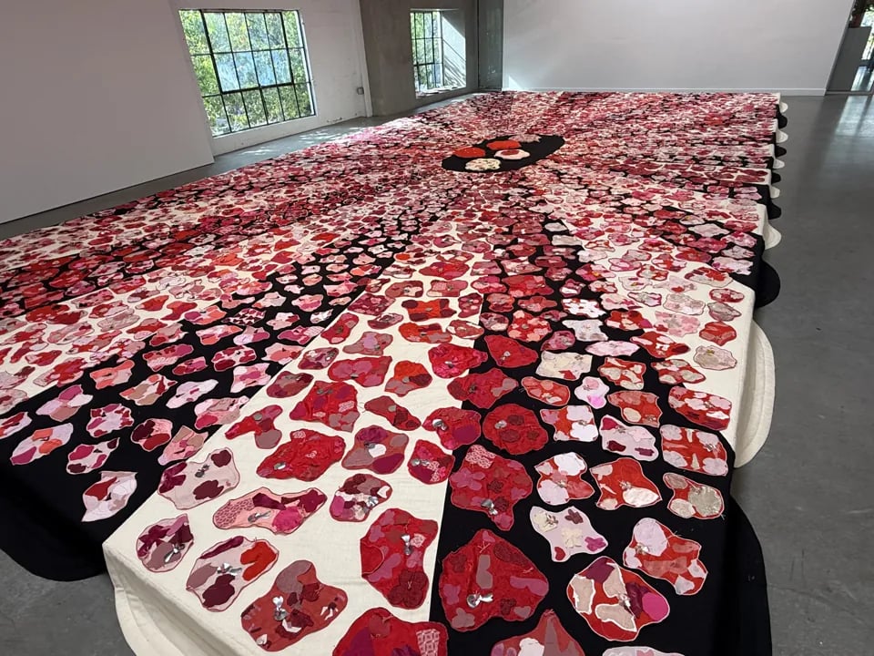 Soft Spaces for Hard Times textile floor installation at Minnesota Street Project with red and pink fabric patterns.