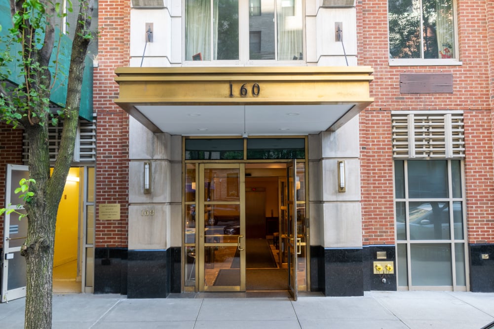 Residential building entrance at 160 West 86th Street, with a gold canopy and glass doors.