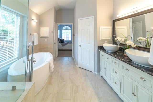Primary bathroom with a freestanding tub, glass shower, and double vanity with vessel sinks.