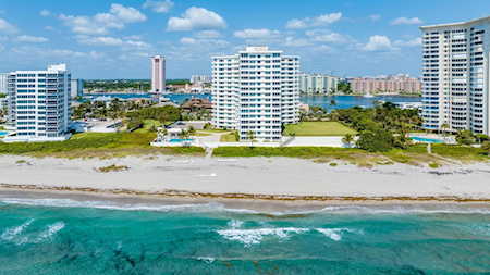Aerial view of East Boca beachfront condos lining the shore beside turquoise water.