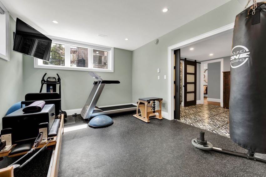 Home gym with a treadmill, hanging punching bag, and exercise equipment.