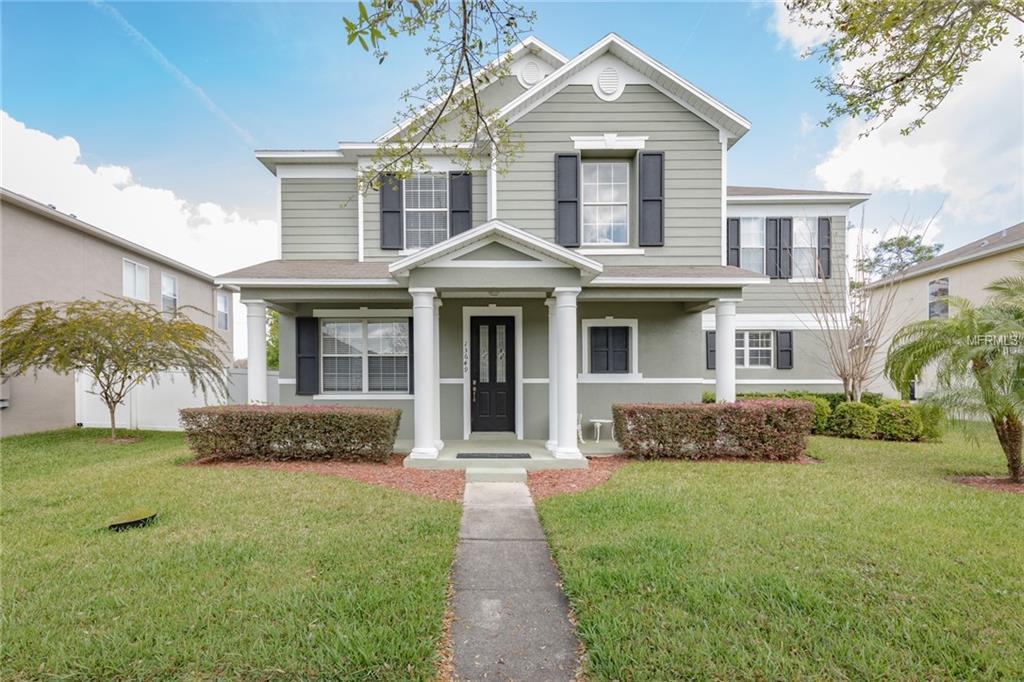 Two-story gray house with white columns, black shutters, and a walkway across the front lawn.