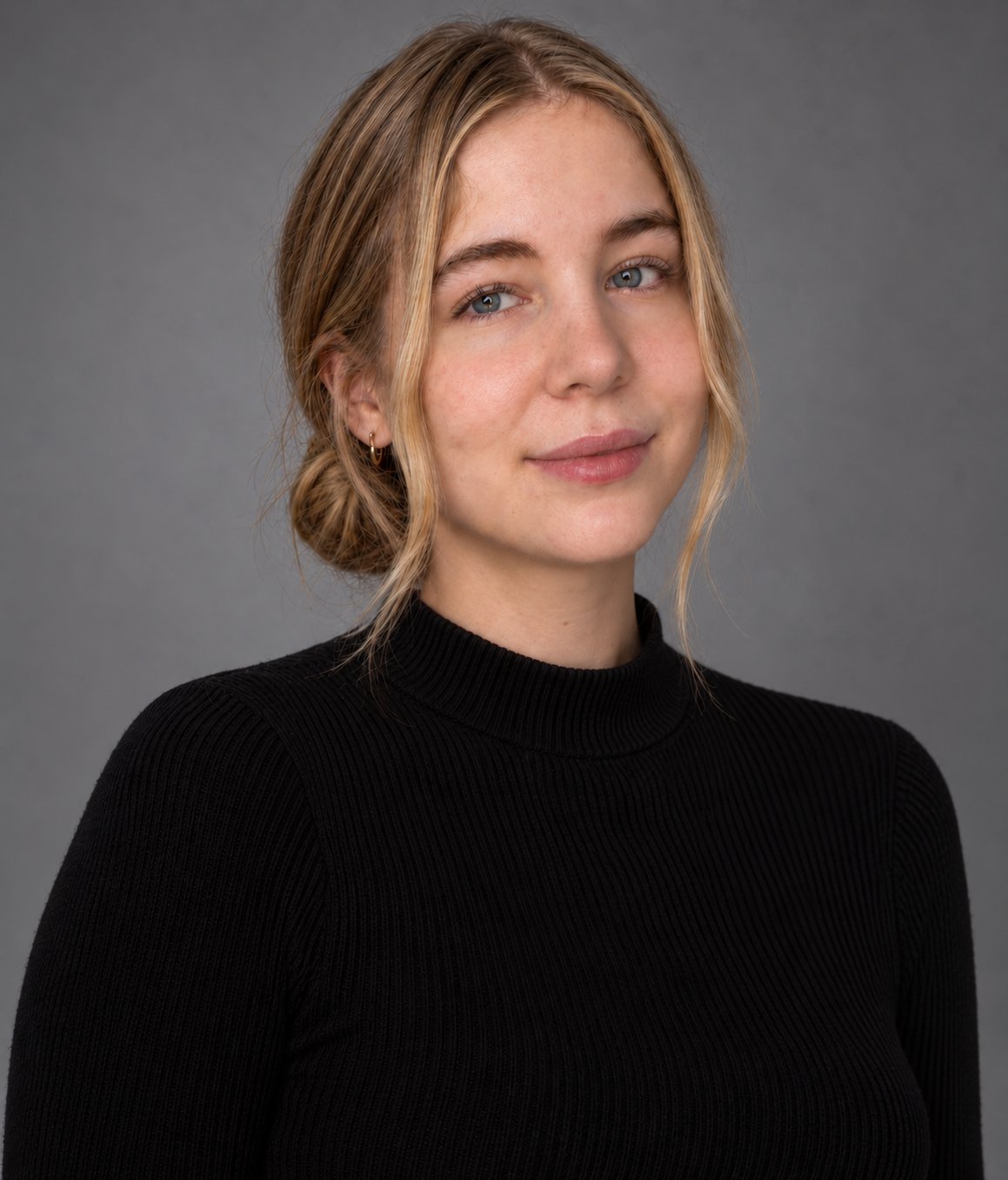 Giselle Vinel-Trainer in a black ribbed sweater against a gray studio background.