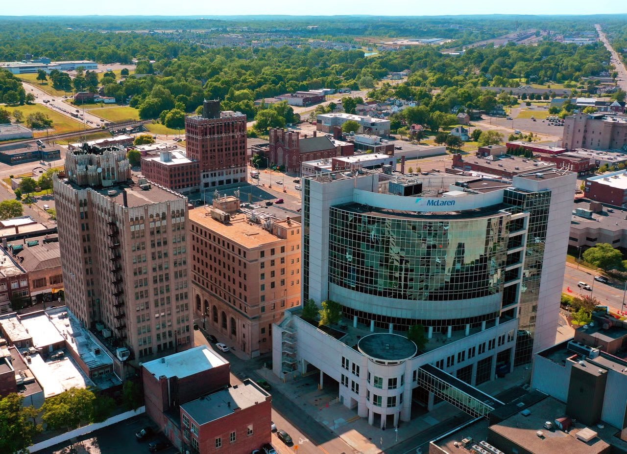 Aerial downtown view with historic brick buildings and a glass McLaren building.